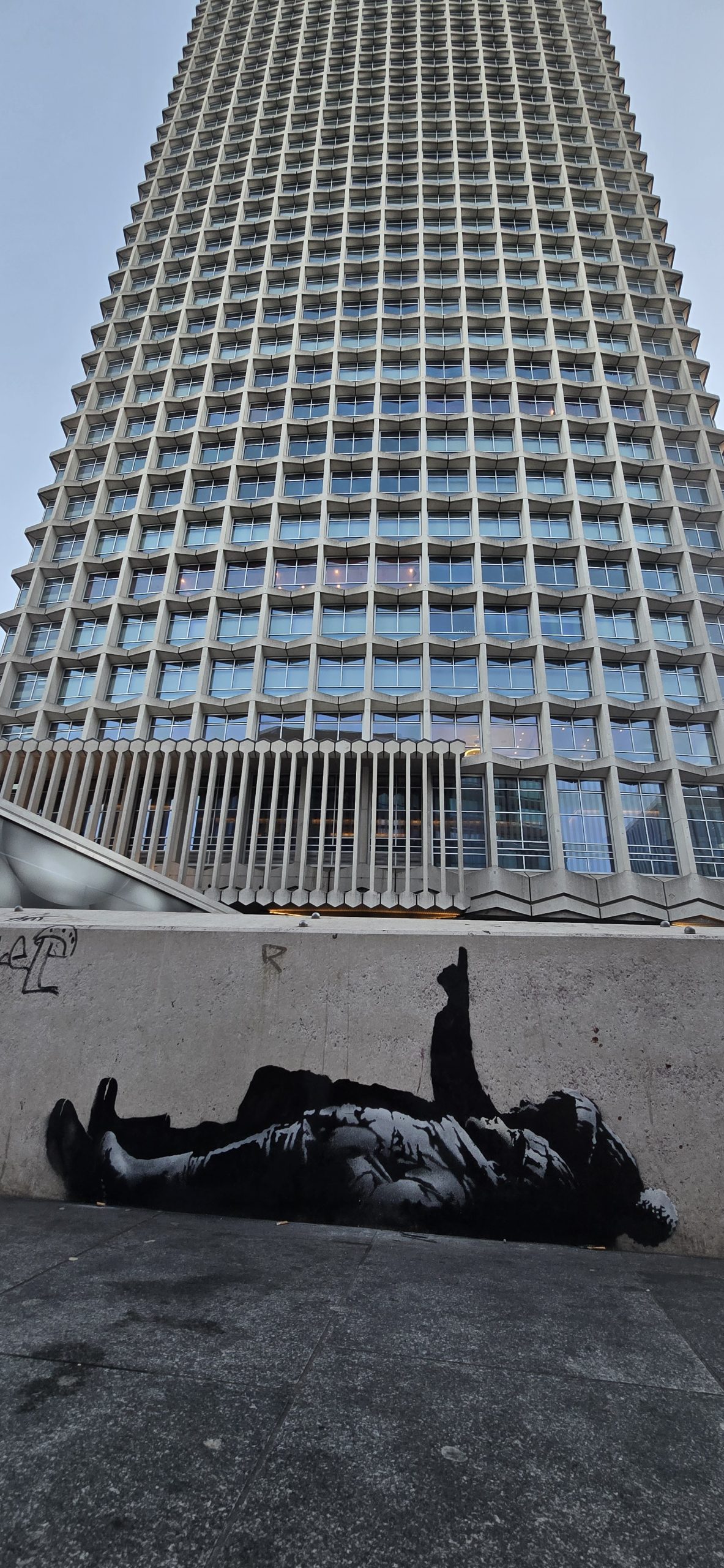 Children lying beneath Centre Point in Banksy Christmas mural highlighting youth homelessness