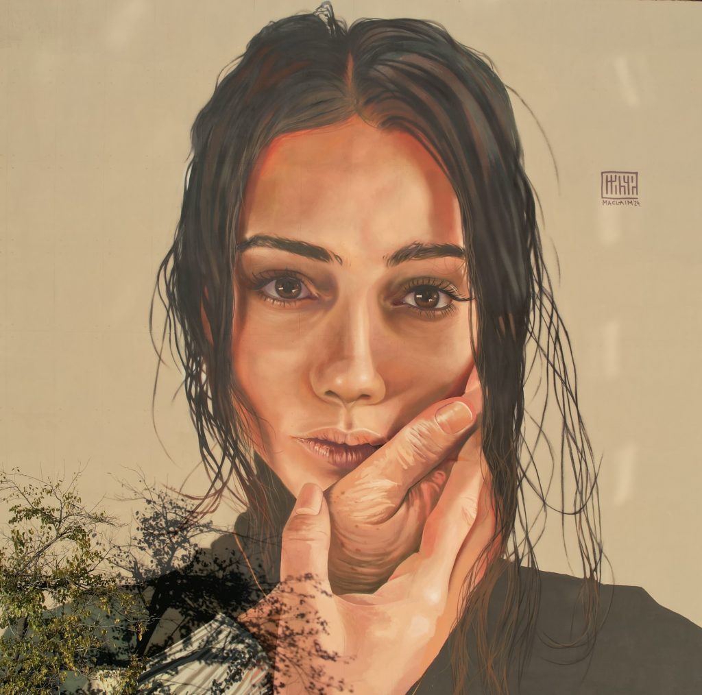Maclaim mural Mariam Tbilisi detail showing signature hands and photorealistic portrait