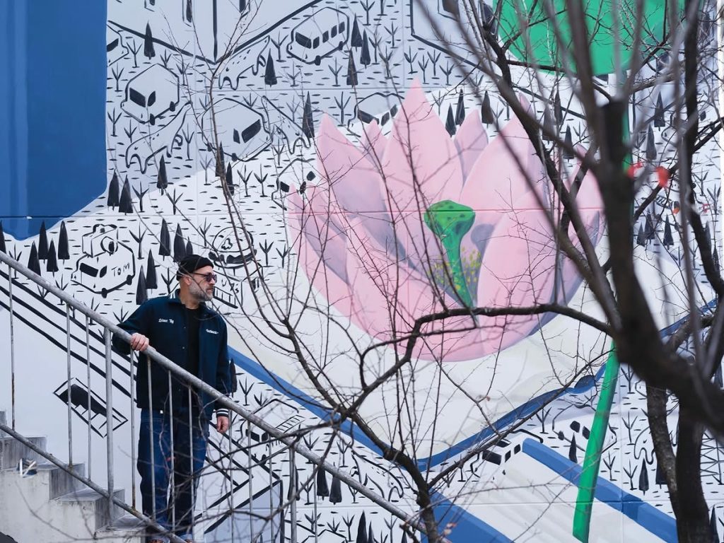 Millo artist standing near The Book of Life mural Shanghai Yangpu district.
