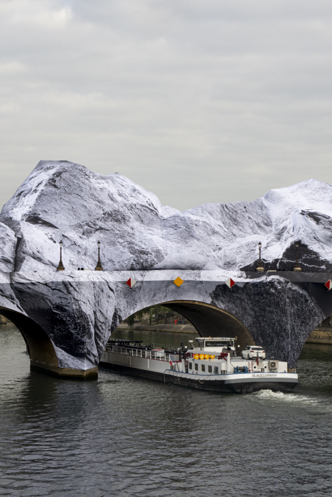 JR Pont Neuf Paris, La Caverne du Pont Neuf seen from the Seine with a river vessel passing beneath the cave structure, Paris, May 2026.