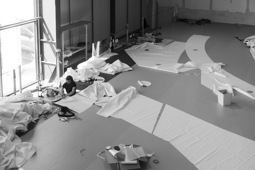 JR Pont Neuf Paris, artisan hand-stitching the printed fabric for La Caverne du Pont Neuf at the Air Toiles Concept workshop in Plougoumelen, Brittany, 2026