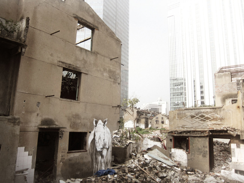 Faith47 Taming the Beast rhino mural surrounded by rubble in Shanghai